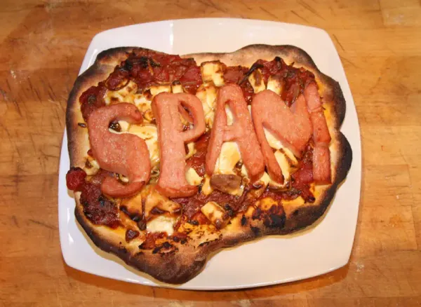 A spam pizza with the word 'spam' spelled out in spam meat.