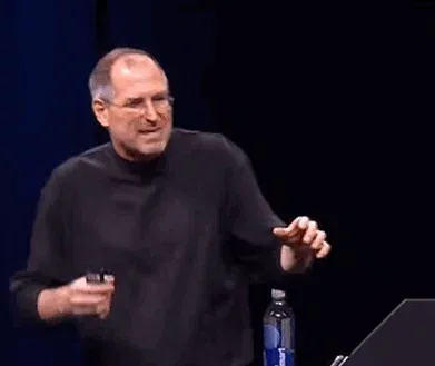 Steve Jobs doing a strange movement, touching his shoe, and laughing