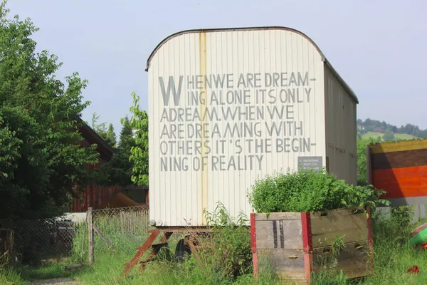 a van with a painted slogan: when we are dreaming alone, it is only a dream. we are dreaming with others, it is the beginning of a reality